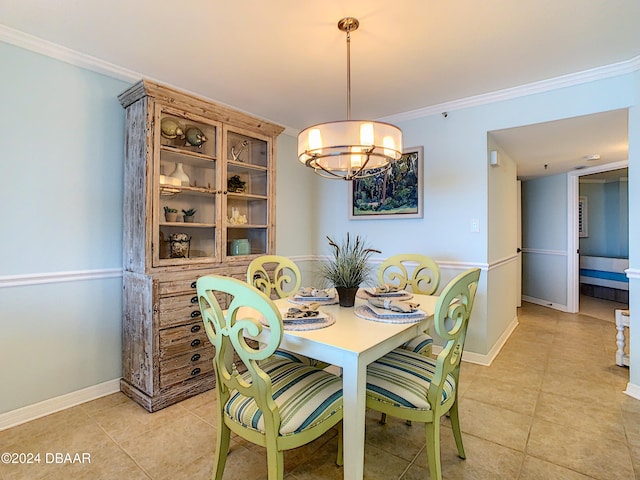 tiled dining space featuring an inviting chandelier and crown molding