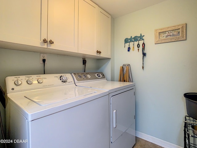 washroom featuring washing machine and dryer and cabinets