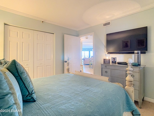 carpeted bedroom with a closet and crown molding