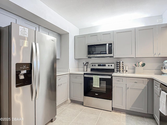 kitchen featuring gray cabinets, stainless steel appliances, and light countertops