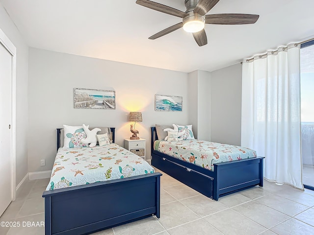 bedroom featuring a ceiling fan, baseboards, and light tile patterned floors