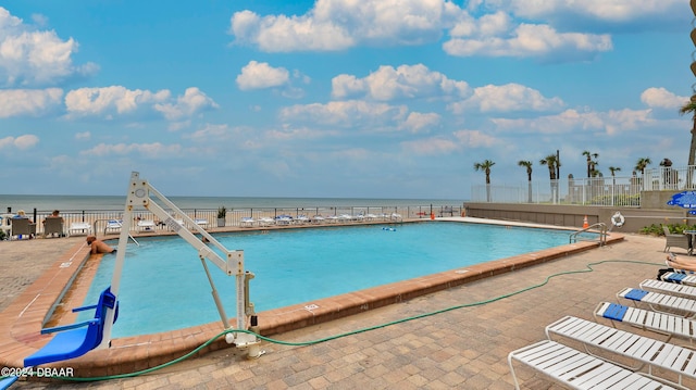 view of pool featuring a patio area and a water view