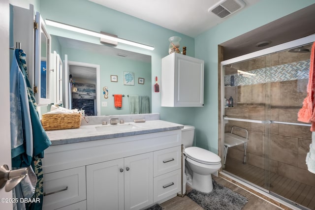 bathroom featuring vanity, toilet, and walk in shower