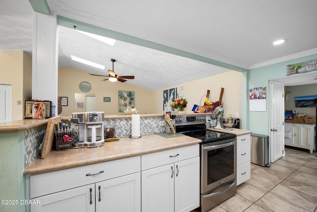 kitchen featuring light tile patterned floors, crown molding, white cabinetry, vaulted ceiling with skylight, and stainless steel electric range oven