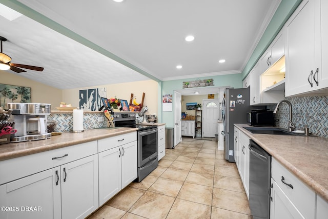 kitchen featuring appliances with stainless steel finishes, white cabinetry, sink, backsplash, and light tile patterned floors