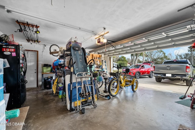 garage featuring a garage door opener and black fridge