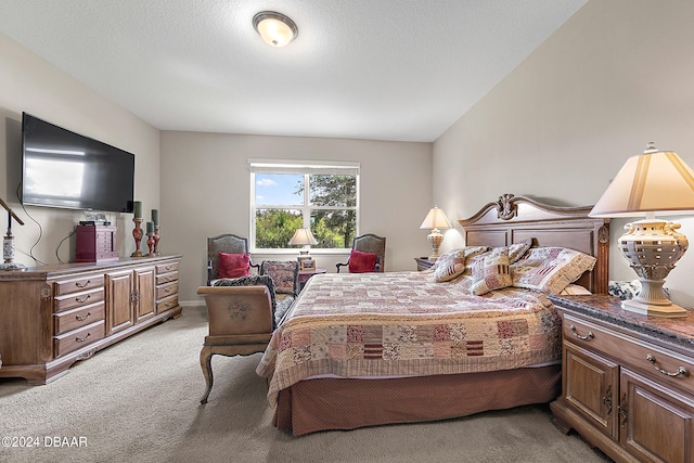 bedroom with a textured ceiling and light colored carpet