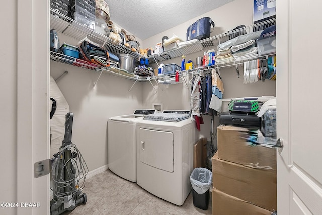 laundry room with a textured ceiling and washer and clothes dryer