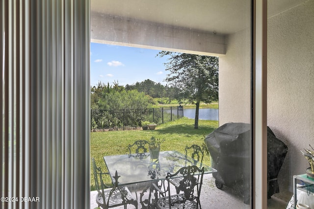 sunroom featuring a water view