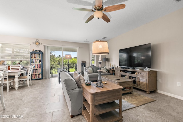 tiled living room with a textured ceiling and ceiling fan