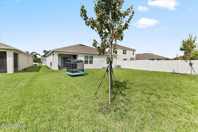 2714 Neverland Dr, New Smyrna Beach, FL 32168 - back of property featuring a trampoline and stucco siding