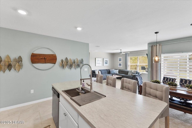 2714 Neverland Dr, New Smyrna Beach, FL 32168 - kitchen with white cabinetry, stainless steel dishwasher, open floor plan, pendant lighting, and light countertops