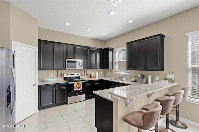 2916 Meleto Blvd, New Smyrna Beach, FL 32168 - kitchen featuring stainless steel appliances, a sink, a peninsula, plenty of natural light, and recessed lighting