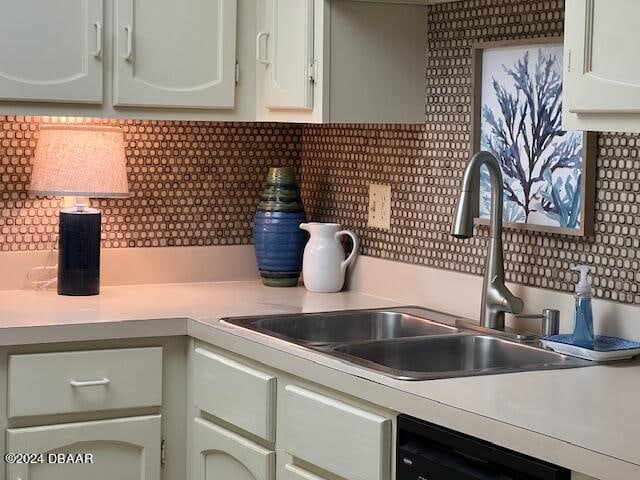 4175 S Atlantic Ave Unit 1240, New Smyrna Beach, FL 32169 - kitchen featuring white cabinets, black dishwasher, sink, and tasteful backsplash