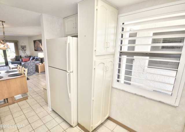 4175 S Atlantic Ave Unit 1240, New Smyrna Beach, FL 32169 - kitchen featuring white cabinets, hanging light fixtures, light tile patterned flooring, and white fridge