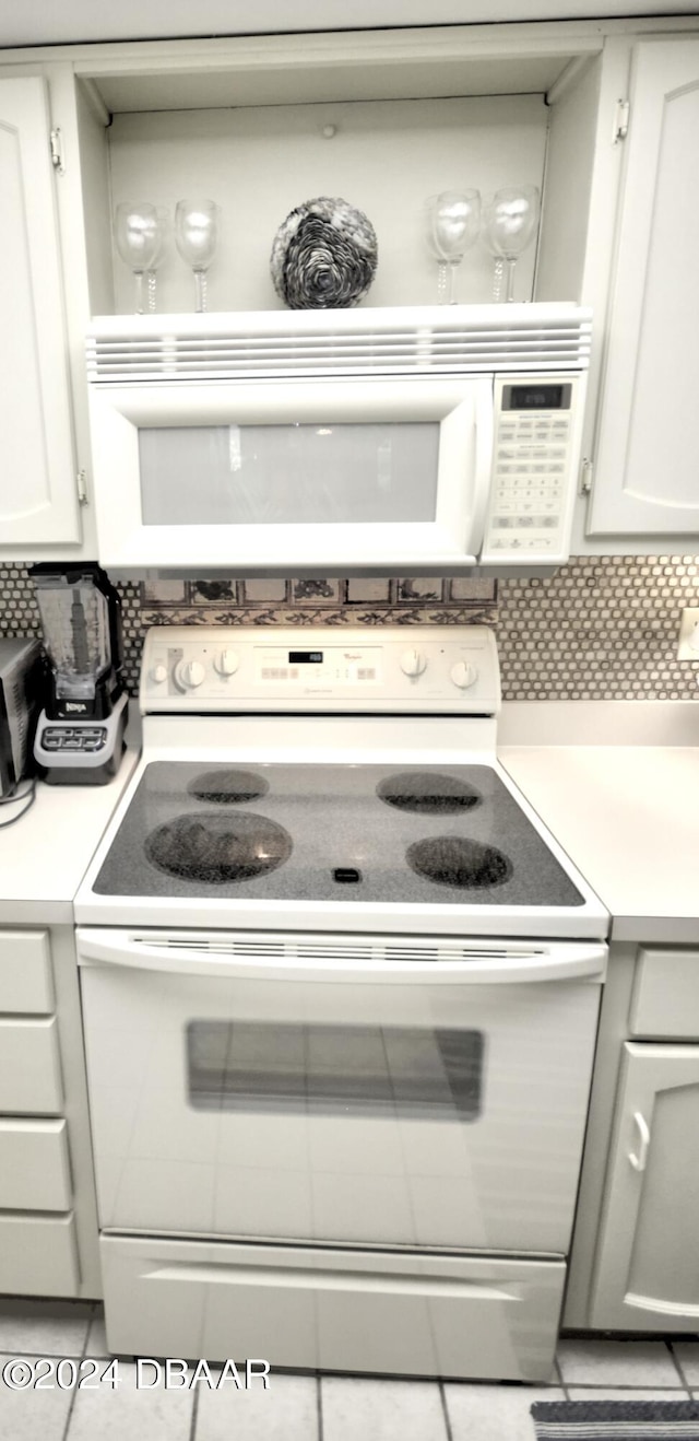 4175 S Atlantic Ave Unit 1240, New Smyrna Beach, FL 32169 - kitchen featuring white cabinetry, light tile patterned floors, and white appliances