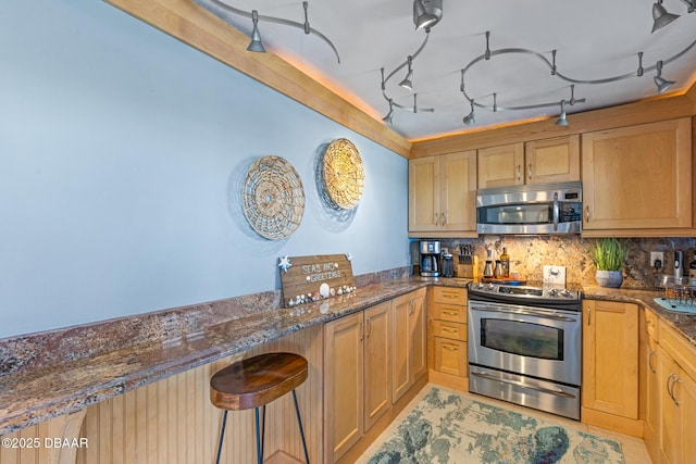 kitchen with decorative backsplash, appliances with stainless steel finishes, and dark stone counters