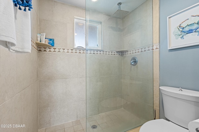 bathroom featuring tiled shower and toilet