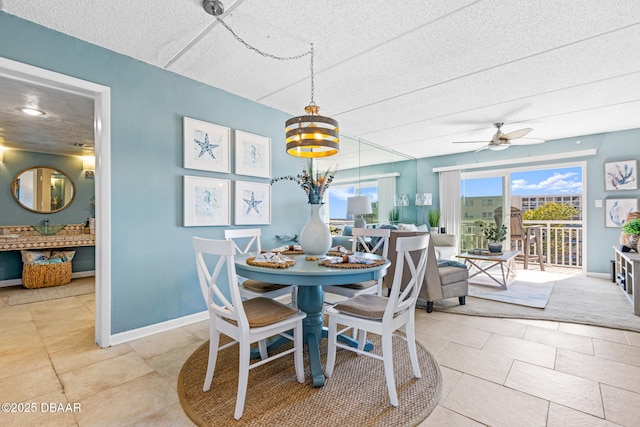 tiled dining space with ceiling fan with notable chandelier