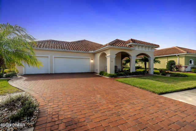 mediterranean / spanish-style house with a front yard and a garage