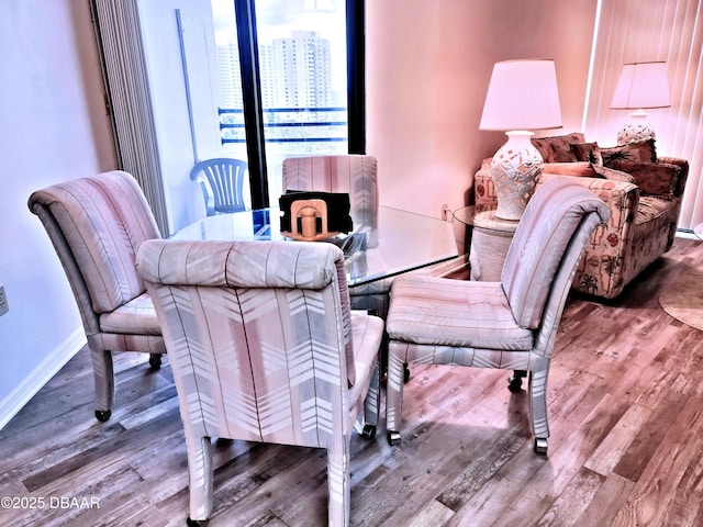 dining area with baseboards and wood finished floors