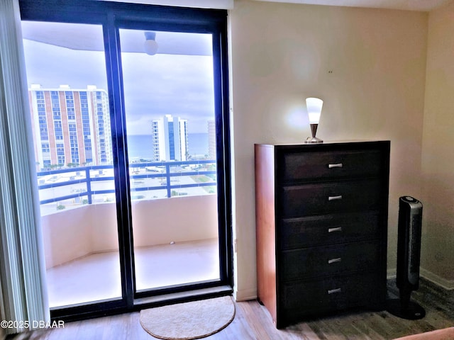 unfurnished bedroom featuring a city view and wood finished floors