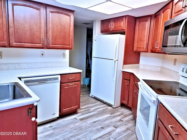 kitchen featuring visible vents, white appliances, light wood-style flooring, and light countertops