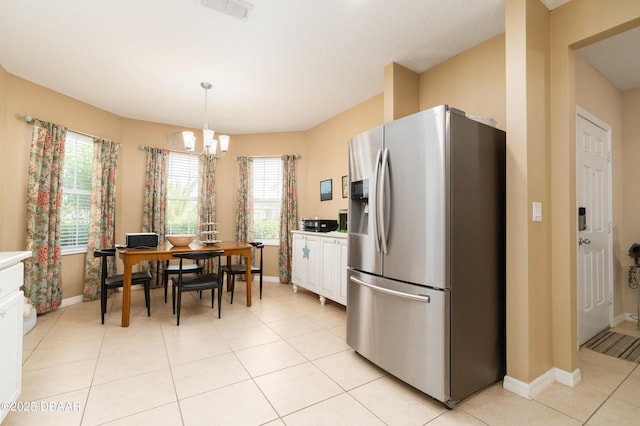 1748 Savannah Ln, Port Orange, FL 32128 - kitchen with stainless steel refrigerator with ice dispenser, white cabinets, a chandelier, baseboards, and light tile patterned flooring