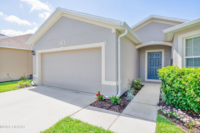 1748 Savannah Ln, Port Orange, FL 32128 - view of front of house featuring a garage, stucco siding, and concrete driveway