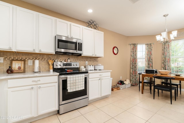 1748 Savannah Ln, Port Orange, FL 32128 - kitchen featuring stainless steel appliances, a chandelier, light countertops, decorative backsplash, and light tile patterned floors