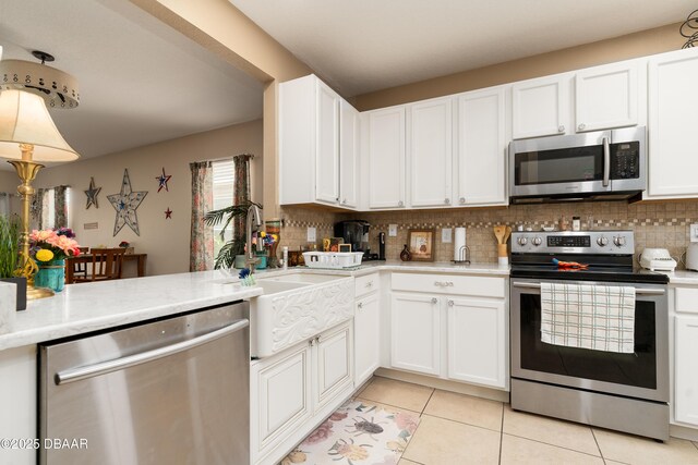 1748 Savannah Ln, Port Orange, FL 32128 - kitchen featuring stainless steel appliances, light countertops, light tile patterned flooring, and backsplash