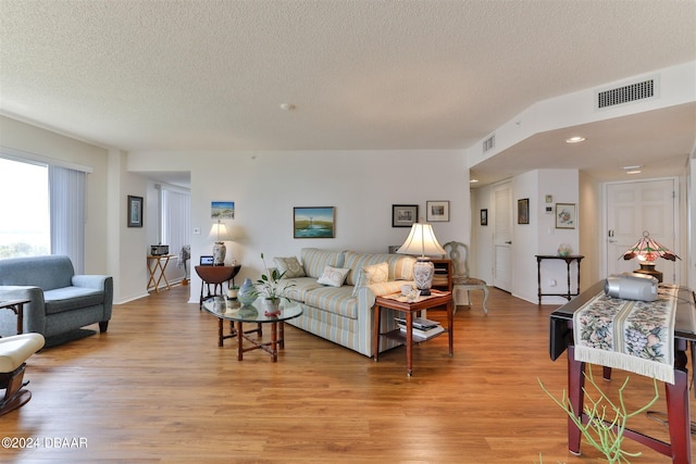 living room featuring light hardwood / wood-style flooring and a textured ceiling