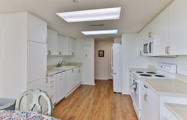 kitchen with white cabinetry, white appliances, sink, and light hardwood / wood-style floors