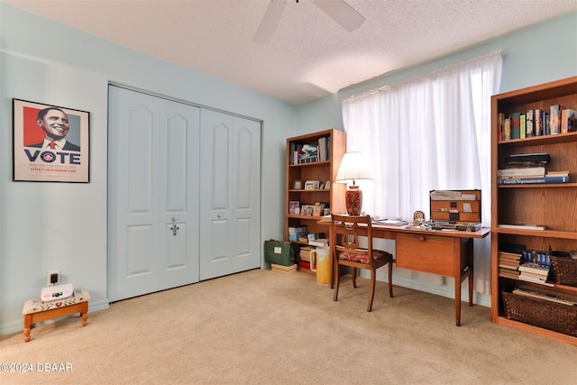 carpeted office featuring ceiling fan and a textured ceiling