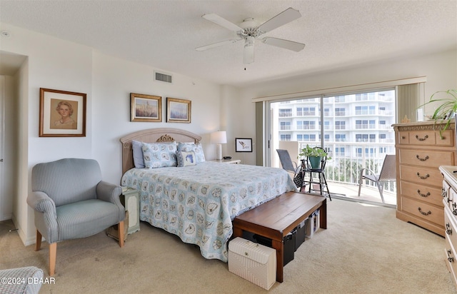 carpeted bedroom with a textured ceiling, ceiling fan, and access to exterior