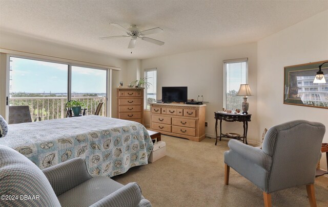 3 Oceans W Blvd Unit 5C4, Daytona Beach Shores, FL 32118 - bedroom featuring access to outside, light colored carpet, multiple windows, and a ceiling fan