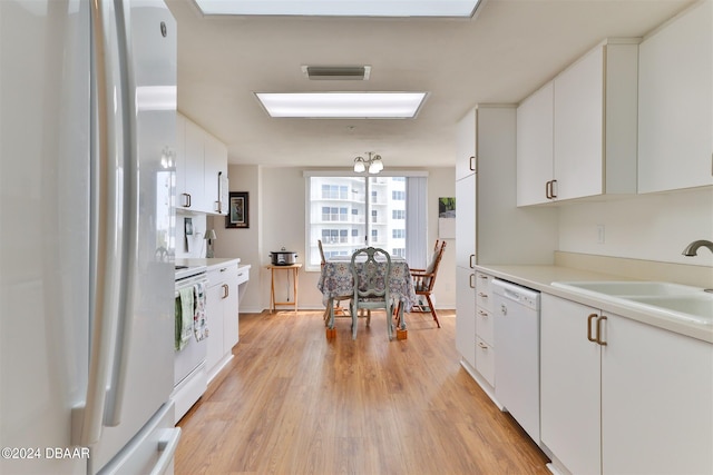 3 Oceans W Blvd Unit 5C4, Daytona Beach Shores, FL 32118 - kitchen featuring white appliances, a sink, white cabinets, light wood-style flooring, and light countertops