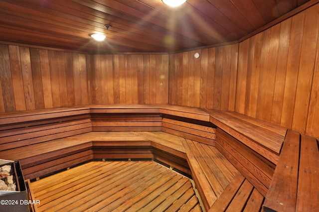 view of sauna with wooden ceiling and wooden walls