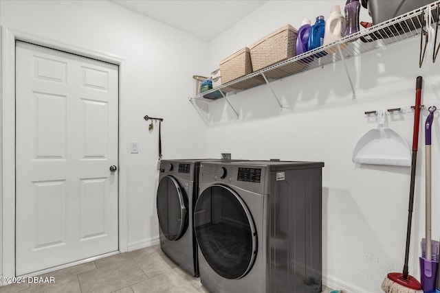 clothes washing area with light tile patterned floors and washing machine and clothes dryer