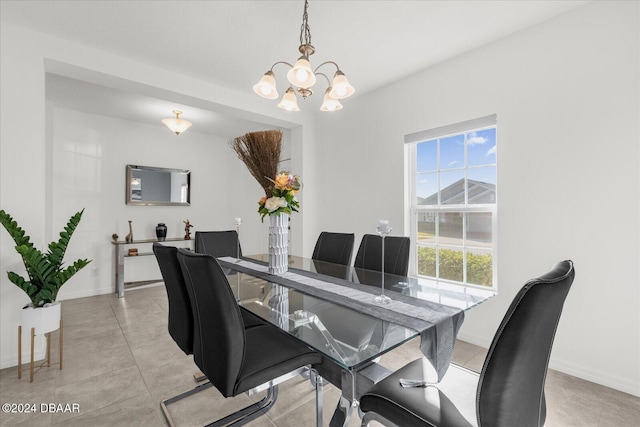 tiled dining space featuring an inviting chandelier