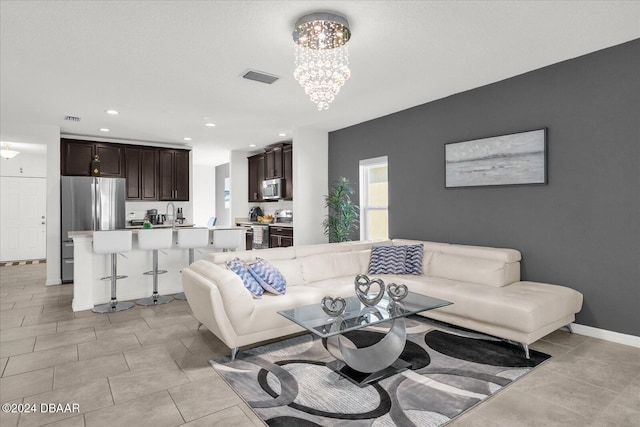 living room with light tile patterned floors and an inviting chandelier