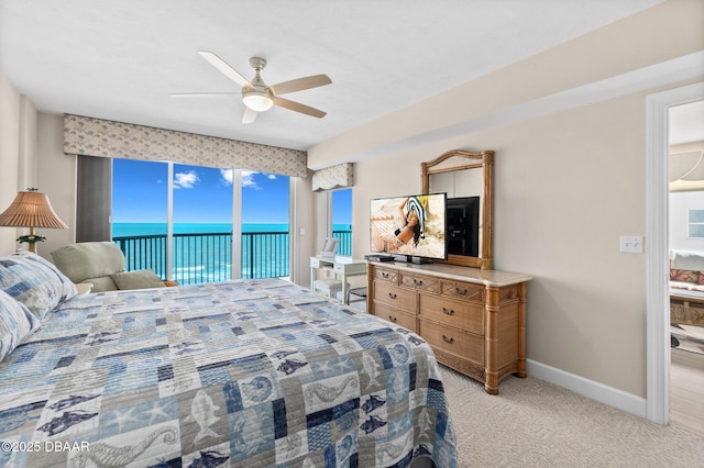 bedroom featuring access to exterior, light colored carpet, and ceiling fan