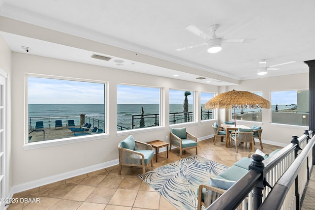 sunroom / solarium featuring a water view and ceiling fan