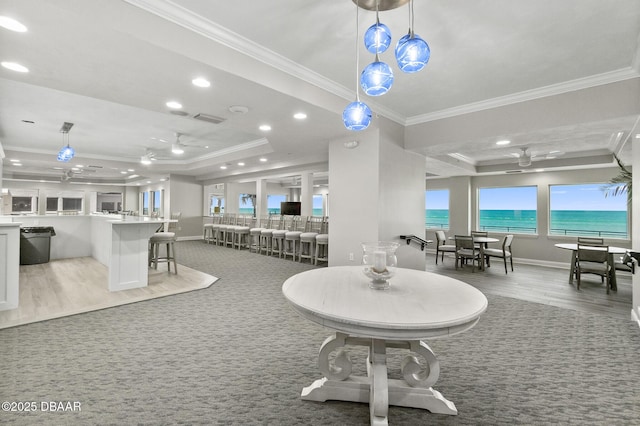 interior space with crown molding, ceiling fan, a raised ceiling, and light carpet