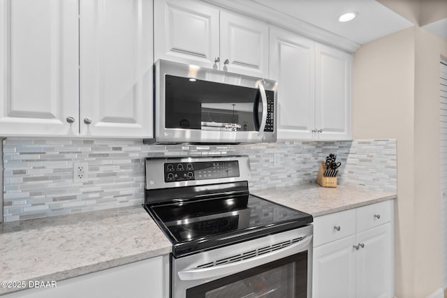 kitchen featuring light stone countertops, stainless steel appliances, and white cabinets