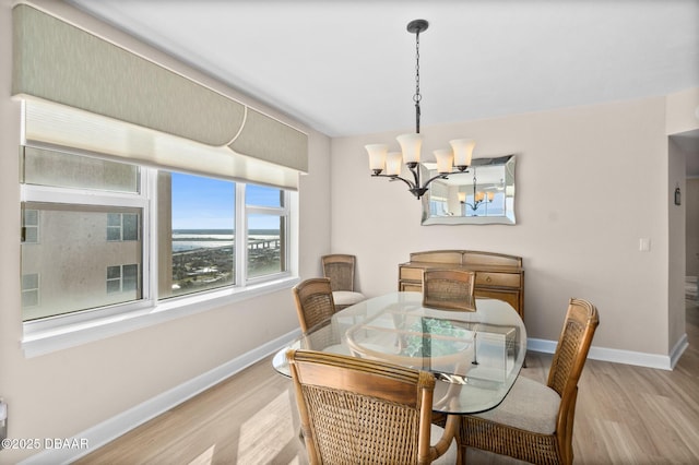 dining space featuring an inviting chandelier and light wood-type flooring