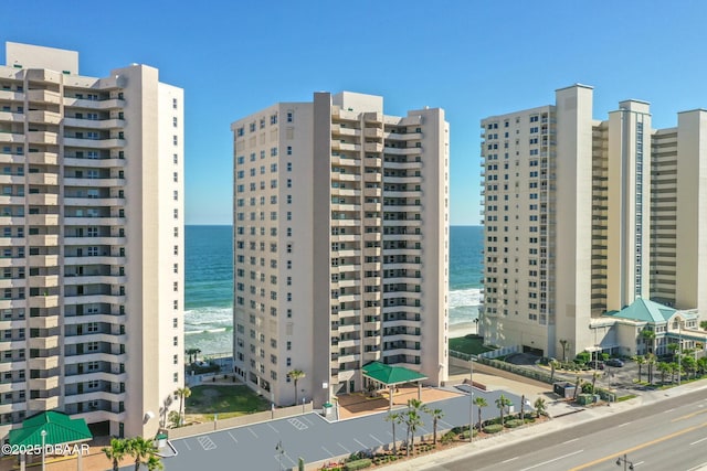 view of building exterior featuring a water view and a view of the beach