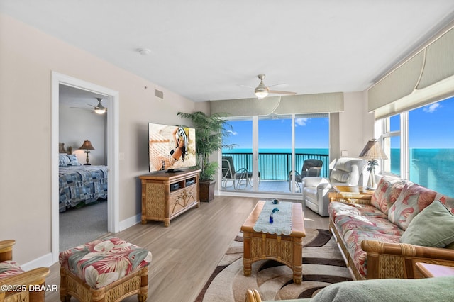 living room with ceiling fan and light hardwood / wood-style floors