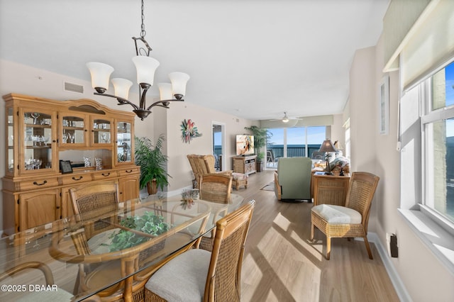 dining room featuring ceiling fan with notable chandelier and light wood-type flooring