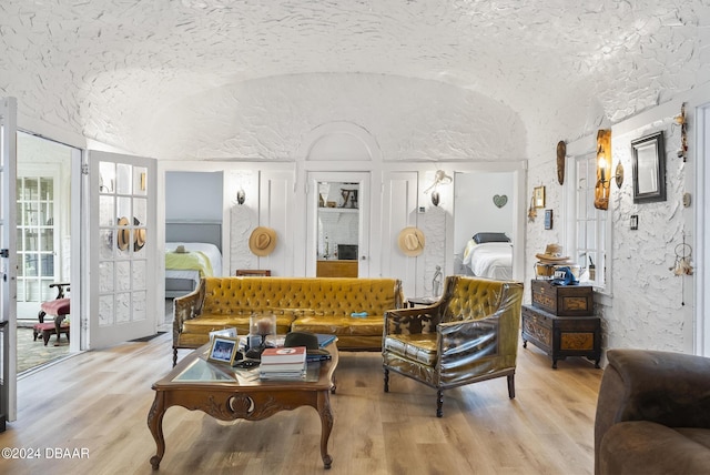 living area with lofted ceiling and light wood-style floors